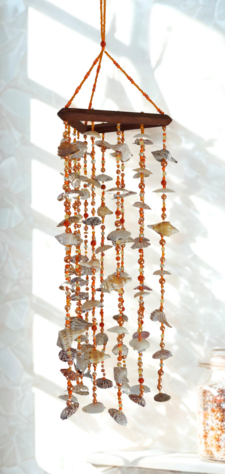Shell wind chime hanging against a white wall