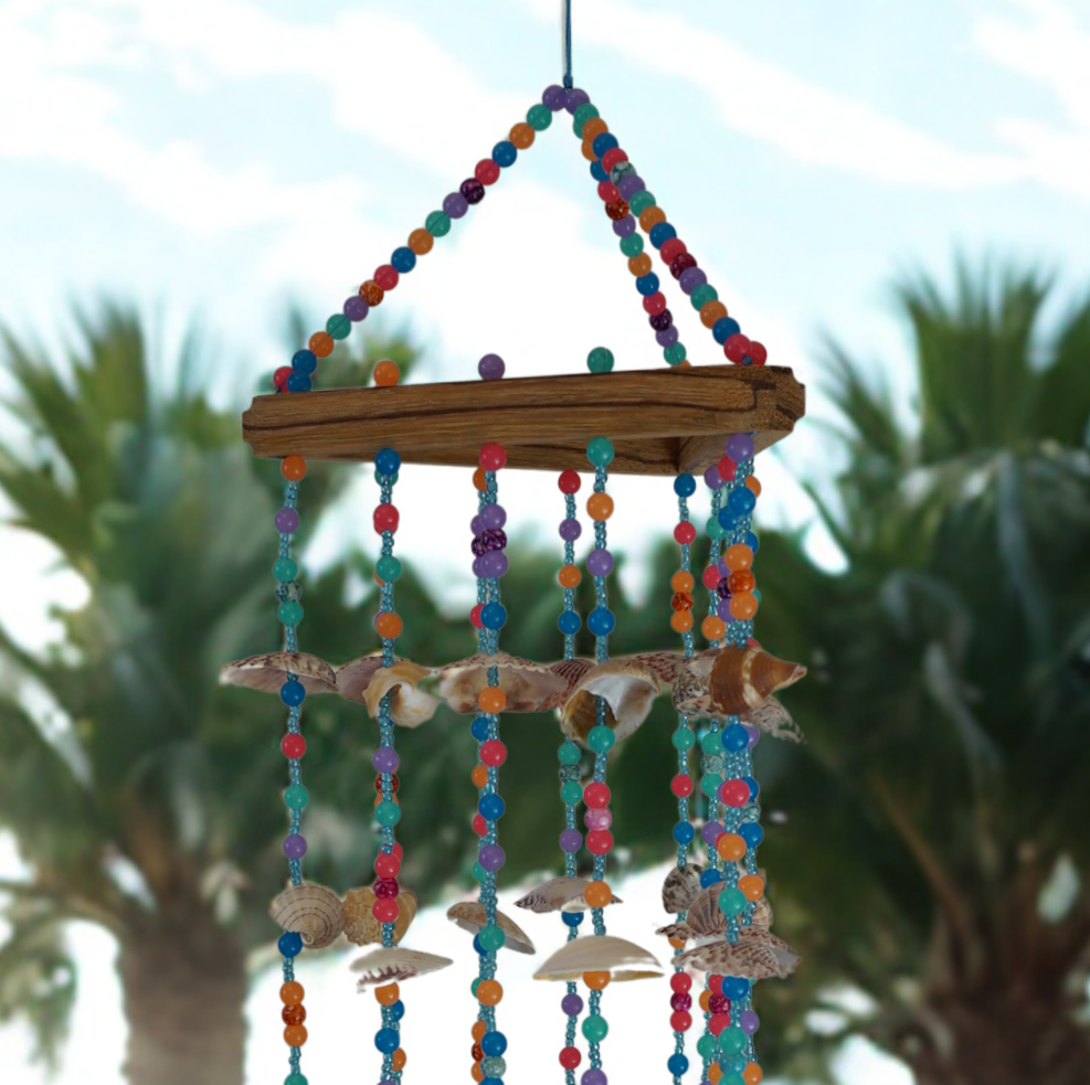 Colorful wind chime with seashells and beads against a blurred outdoor background
