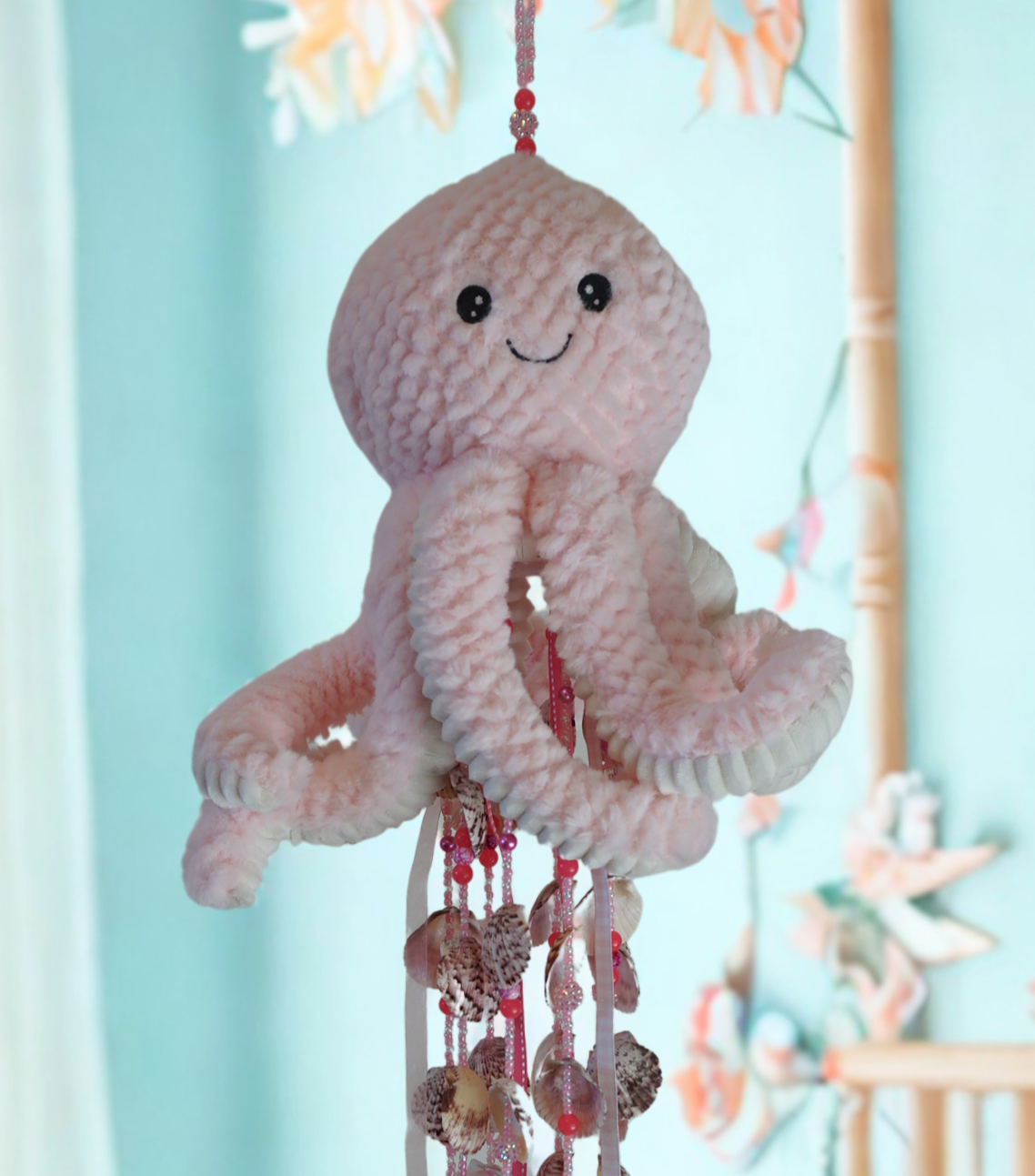 Octopus wind chime with beads and shells against a light blue background