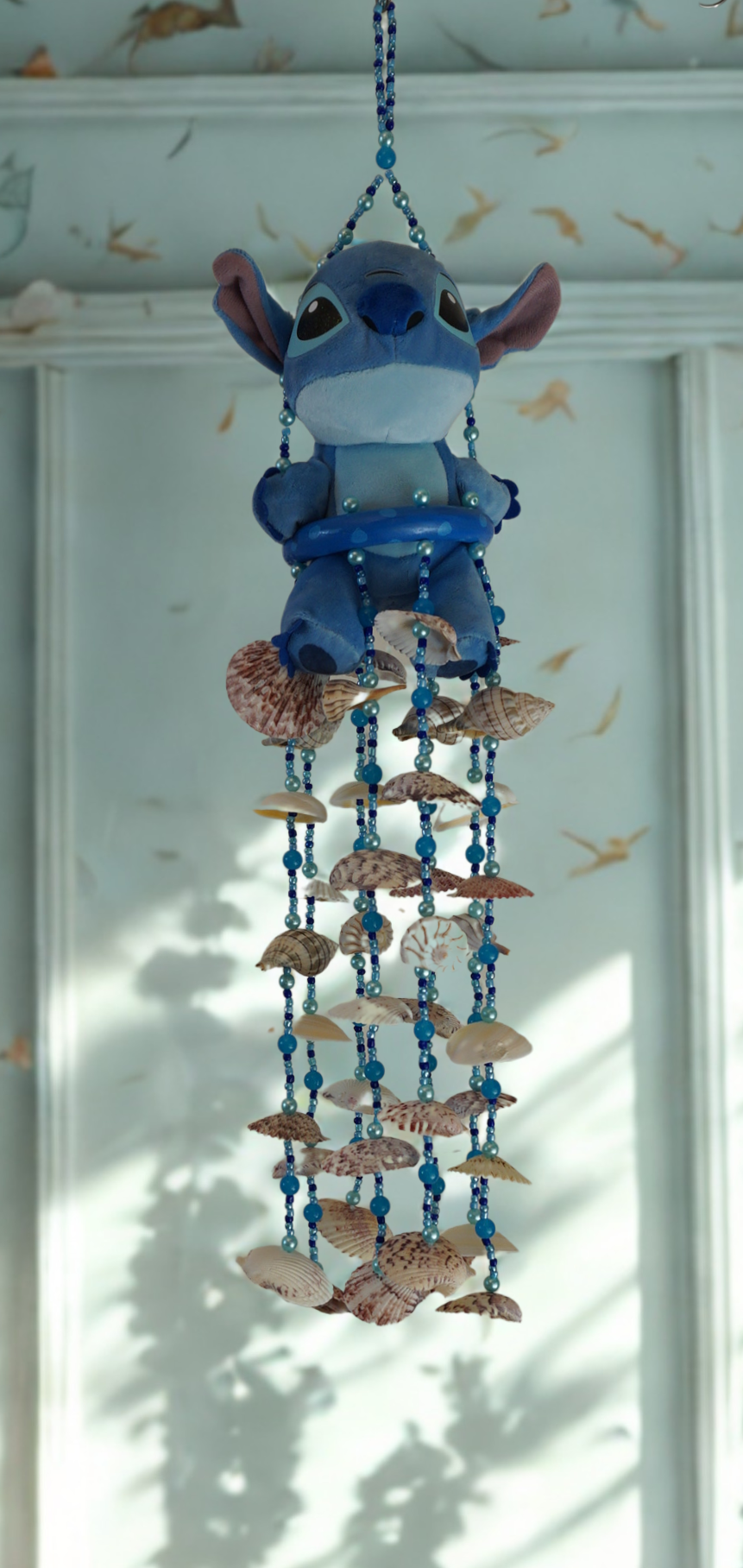 Plush wind chime with seashells and beads on a white background