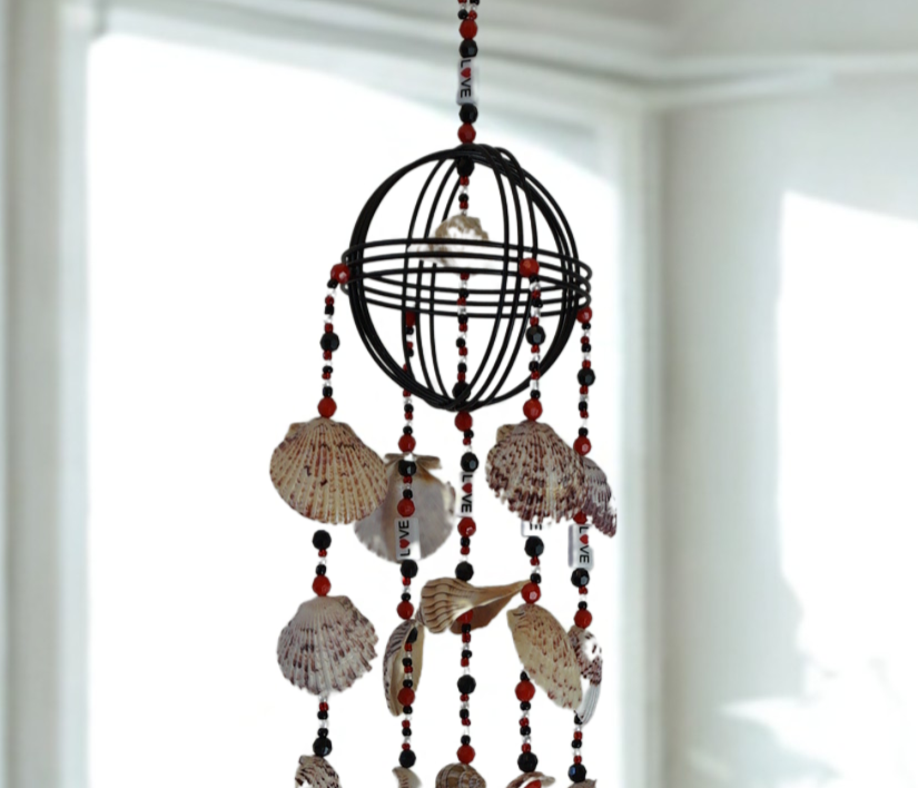 Decorative wind chime with shell and bead elements against a white background