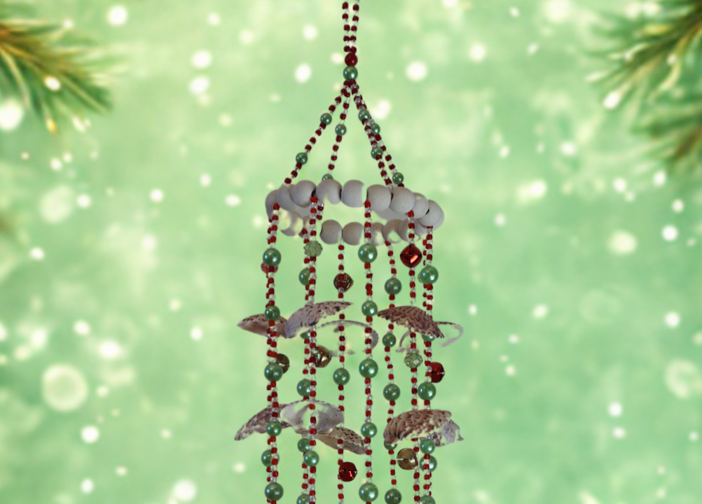 Decorative hanging wind chime with beads and shells against a festive green background.