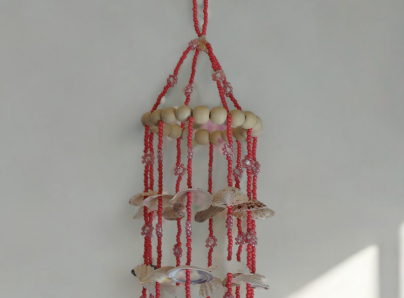 Wood bead and shell wind chime on a plain white background