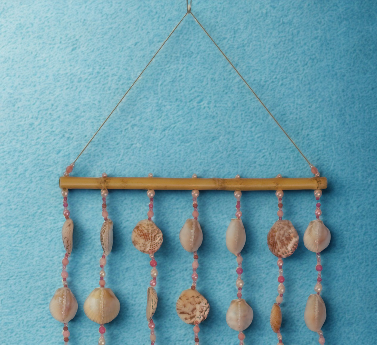 Decorative wall hanging with seashells and beads on a blue background