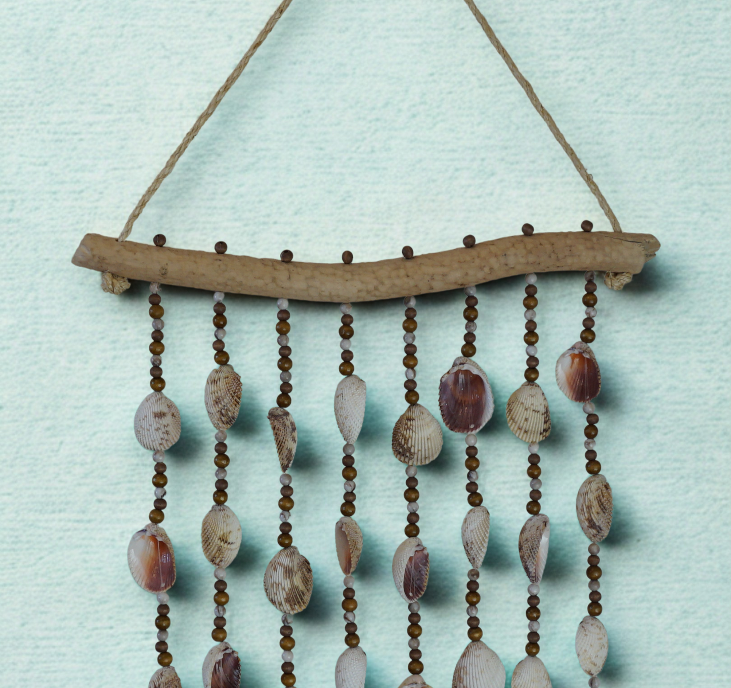Decorative wall hanging with shells and beads on a light blue background