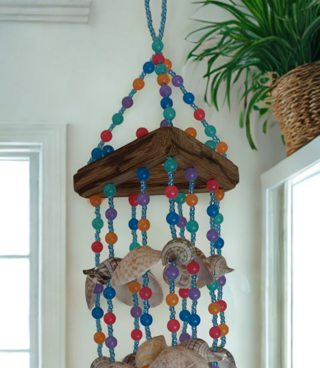 Decorative wind chime with colorful beads and shells hanging indoors.
