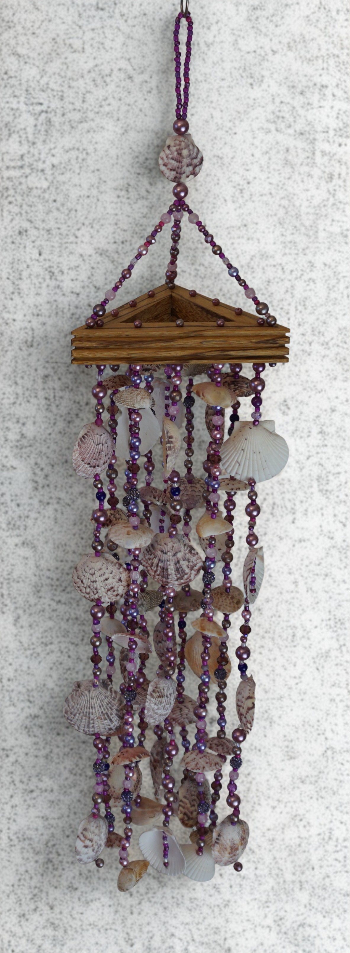 Decorative shell and bead wind chime on a textured white background