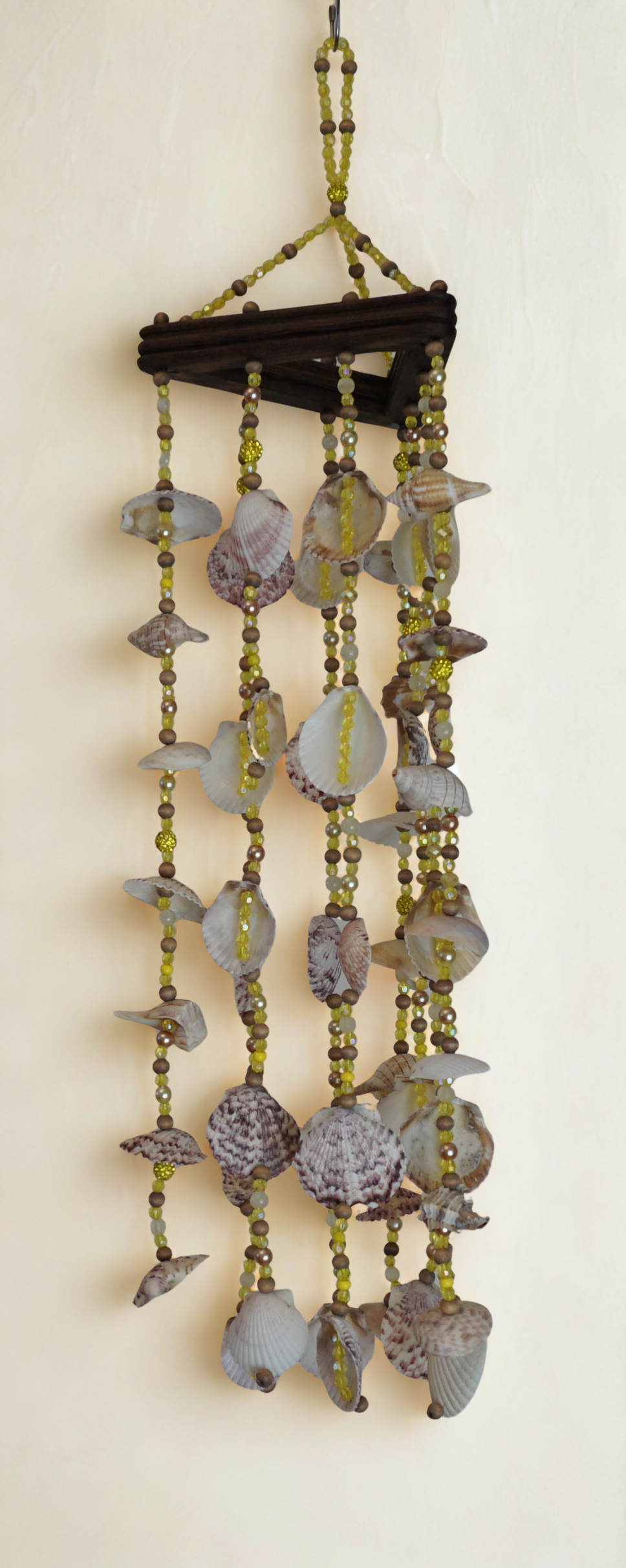 Decorative wind chime with beads and shells on a white background