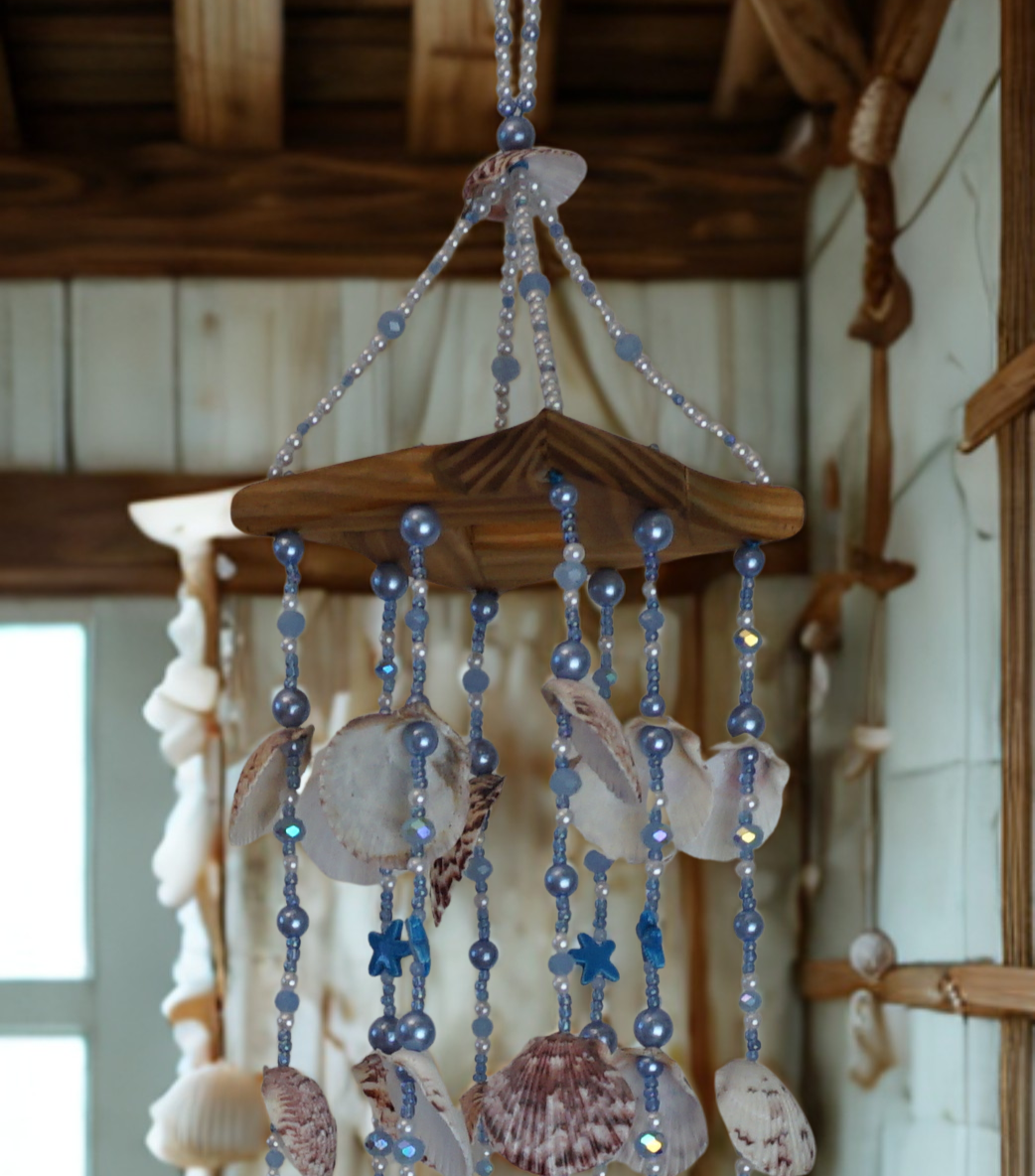 Decorative shell and bead wind chime hanging in front of a wall