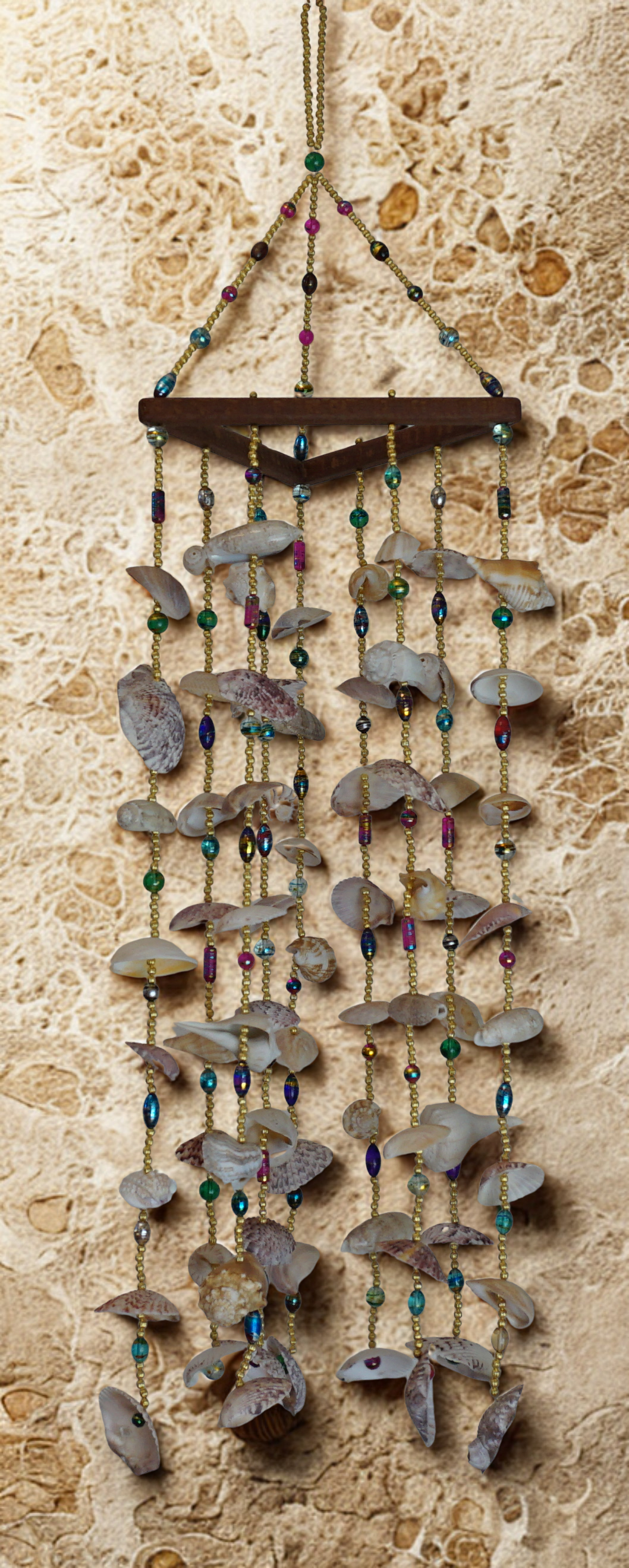 Decorative wall hanging with stones and beads on a textured wall