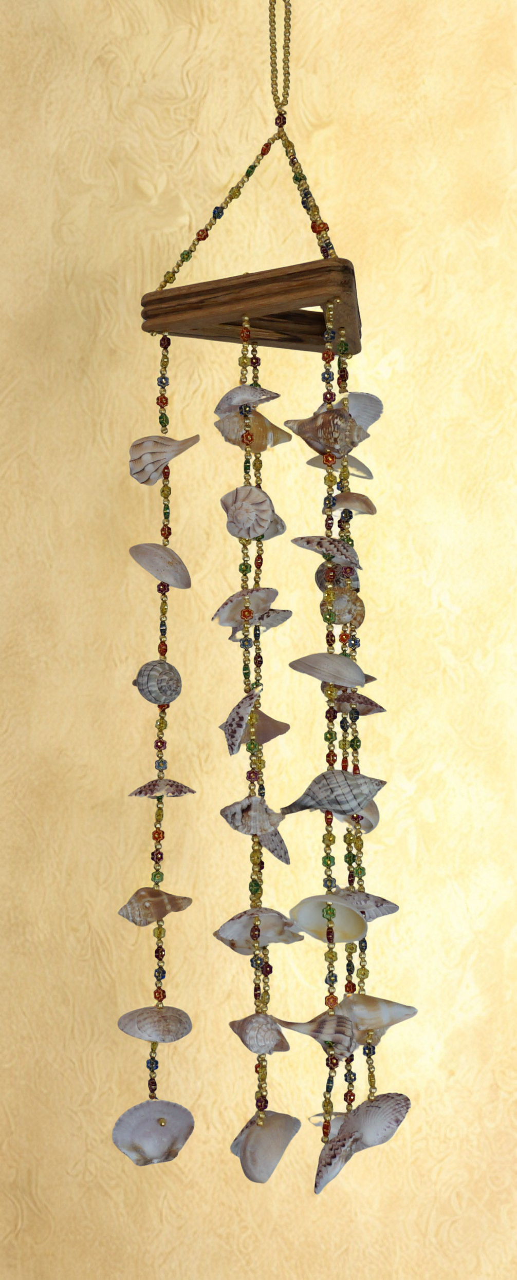 Decorative wind chime with shell elements on a beige background