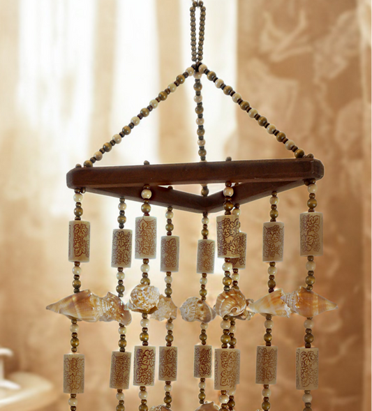 Decorative hanging wind chime with beads, shells and corks, against a neutral background
