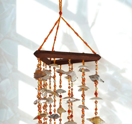 Hanging decorative wind chime with seashells and beads on a white background