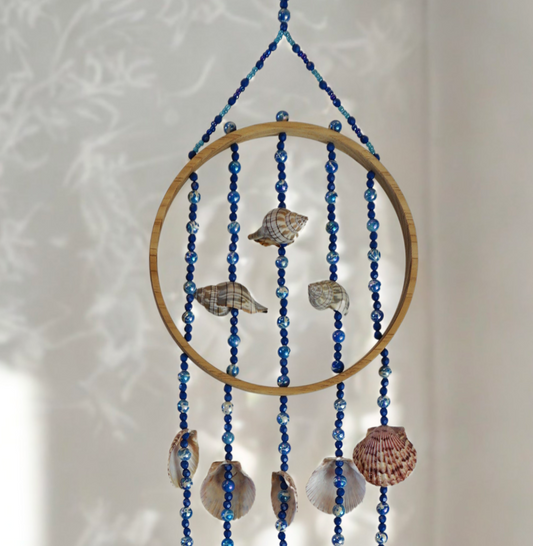 Decorative wall hanging with shells and beads on a white background