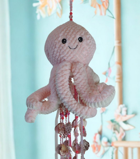 Octopus wind chime with beads and shells against a light blue background