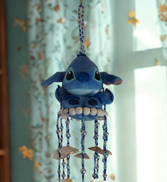 Decorative wind chime with blue character and shell elements in a room setting.