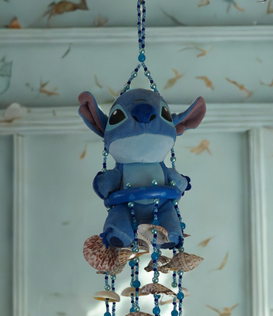Plush wind chime with seashells and beads on a white background