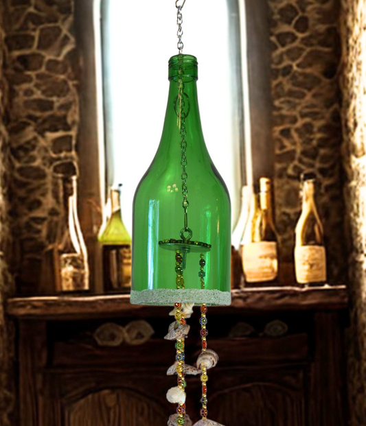 Decorative hanging bottle wind chime with seashells against a rustic stone wall.