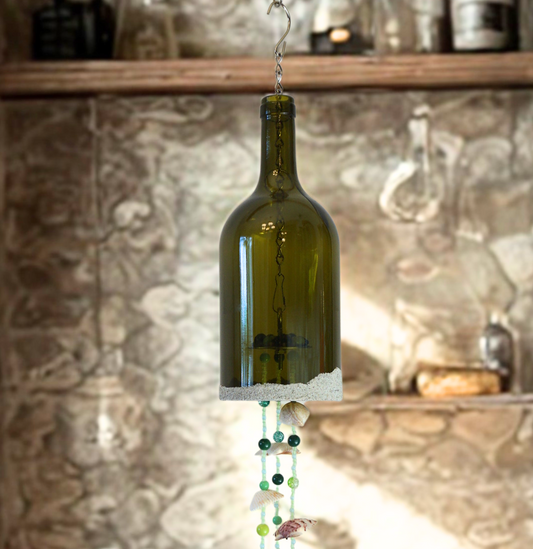 Decorative hanging bottle wind chime with beads and shells against a stone wall background
