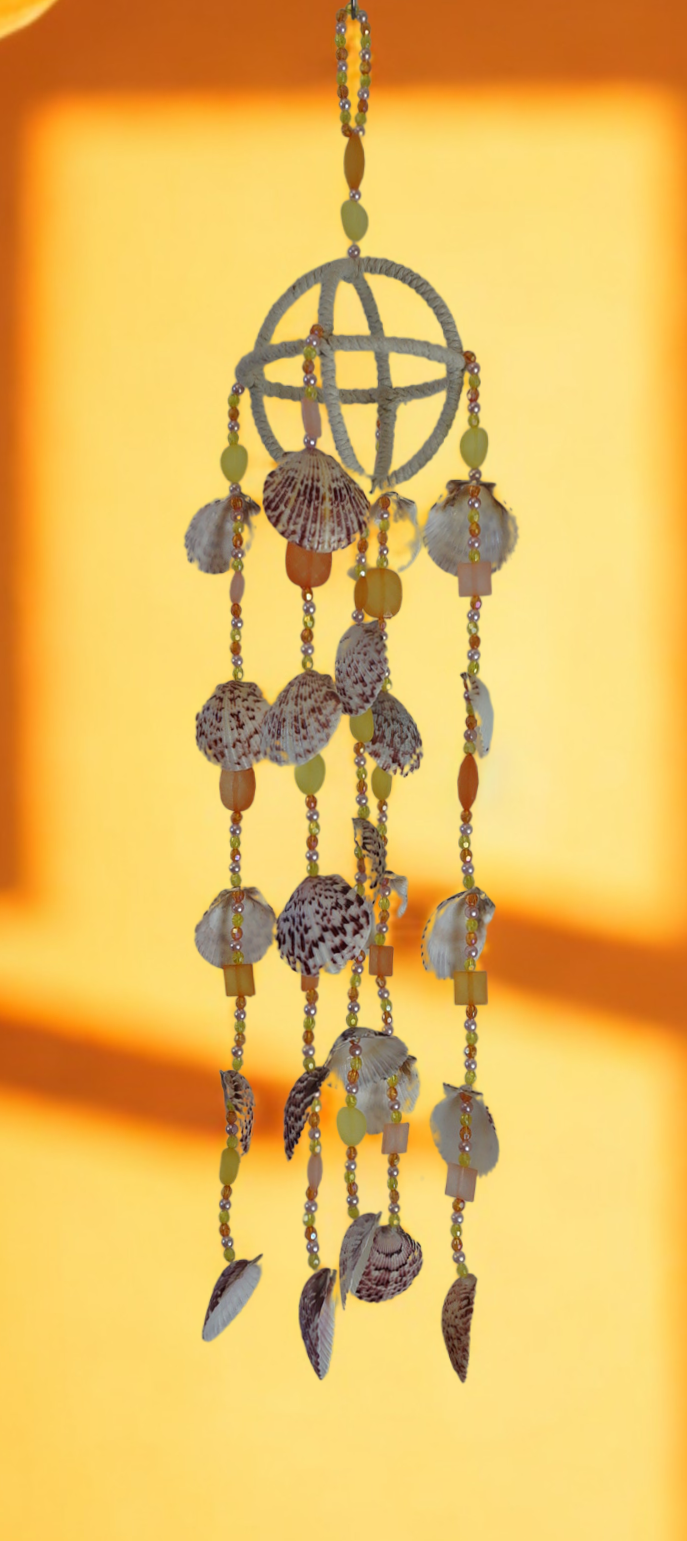 Decorative wind chime with beads and shell elements on a yellow background