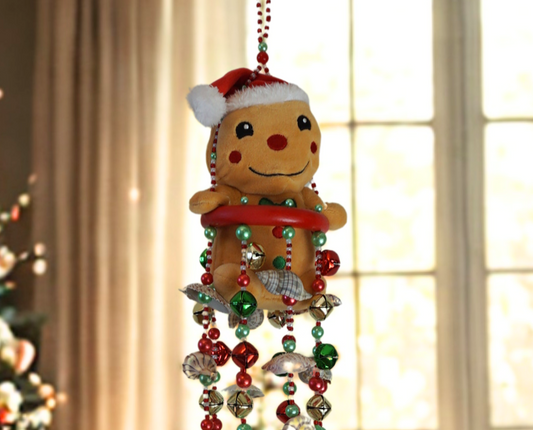 Decorative gingerbread man wind chime  with beads and shells against a blurred indoor background