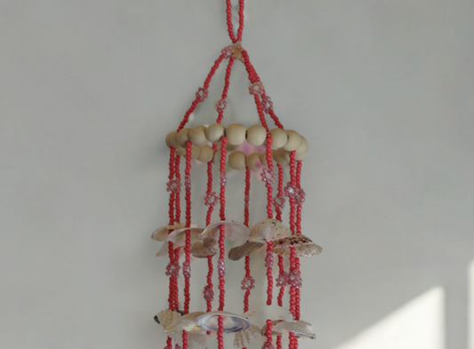 Wood bead and shell wind chime on a plain white background