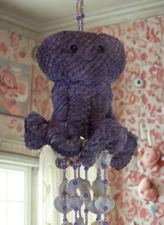 Purple octopus wind chime hanging mobile with beads and shells in a nursery