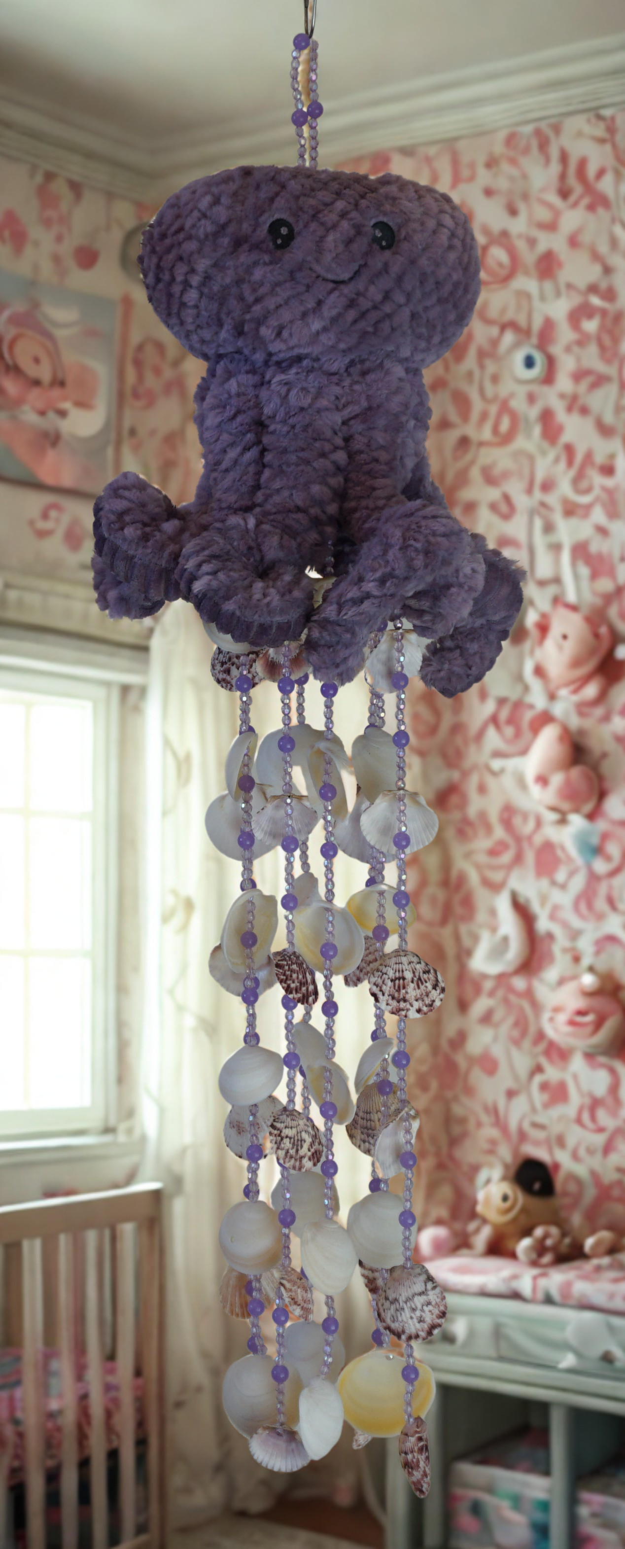 Purple octopus wind chime hanging mobile with beads and shells in a nursery