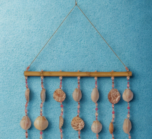 Decorative wall hanging with seashells and beads on a blue background