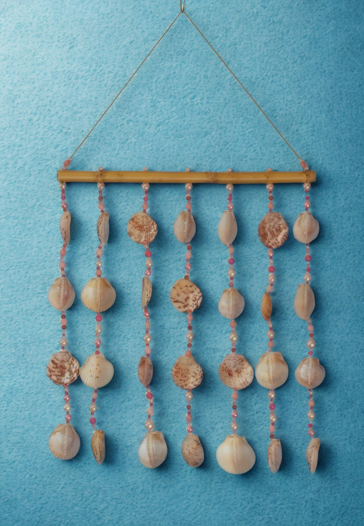 Decorative wall hanging with seashells and beads on a blue background