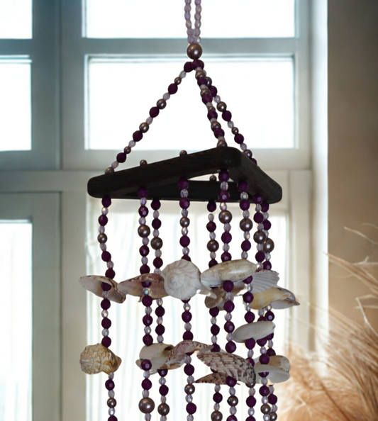 Decorative wind chime with seashells and beads hanging indoors.