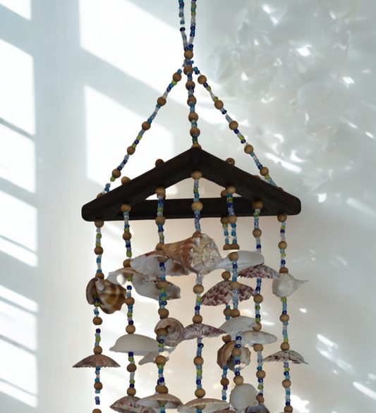 Decorative hanging wind chime made of seashells and beads on a white background