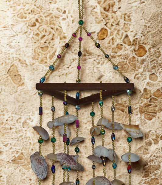 Decorative wind chime with shells and beads on a textured wall