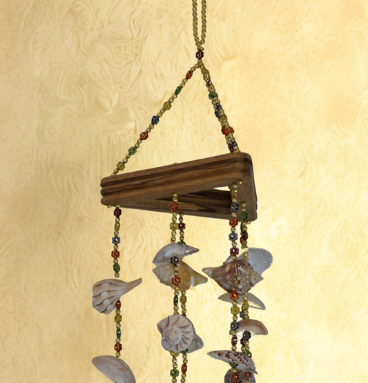 Decorative wind chime with shell and bead elements on a textured beige background